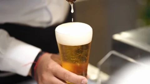 Bartender poured cold lager beer into glass, selective focus, slow-motion 库存影片 121390824