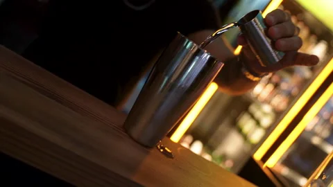 Bartender pouring alcohol from a jigger into a shaker Stock-Footage 331776423