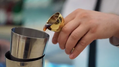 Bartender pouring alcohol into a shaker using a jigger. Close Up Stock Footage 101966073