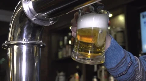 Bartender pouring beer into a beer glass from tap Stock-Footage 59642874