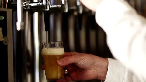 Bartender pouring beer into glass with bubbles close up Stock Footage 124374450