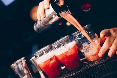 Bartender pouring Cocktail on a bar counter alcoholic drink in nightclub Stock Photos