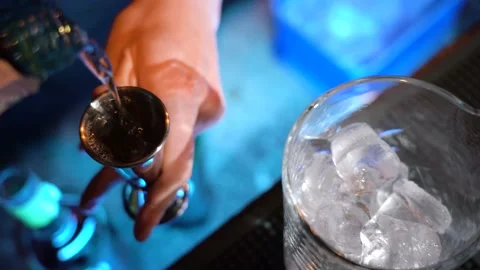 Bartender pouring cocktail Into bartending tumble with cocktail shaker Stock Footage 149125930