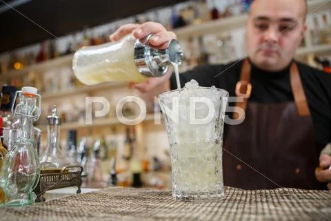 Bartender Pouring Cocktail Into Glass At The Bar