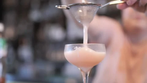 Bartender Pouring Cocktail Through Strainer into Stemmed Glass in Slow Motion 스톡 동영상 305022073