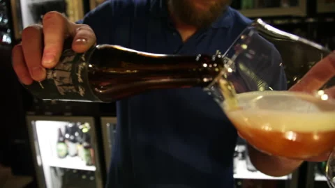 Bartender Pouring Craft Beer From Bottle Into Glass in Brussels Pub Видео 343670640