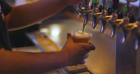 Bartender Pouring Craft Beer from Tap into Pint Glass at Restaurant Bar Video stock 87031436