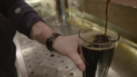 Bartender Pouring Dark Draft Beverage from Tap into Glass at Bar in Beijing Stock Footage 345751478