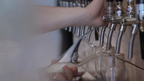 Bartender pouring draft beer in the bar. Close up. Beer is poured into a glass. 動画素材 90083878