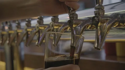 Bartender Pouring Draft Beverage from Tap into Glass at Bar Counter in Beijing Stock Footage 345756663
