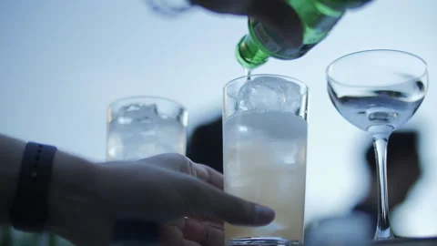 Bartender pouring drink over ice into tall glass Stock Footage 312747980