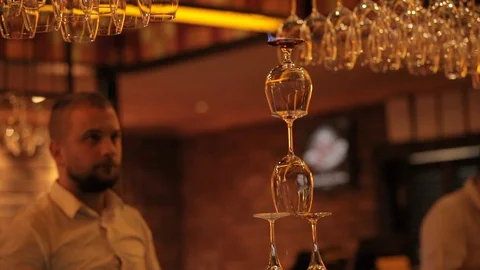 Bartender pouring drink over a stack of glasses in flames Stock Footage 106184256