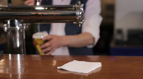 Bartender pouring glass of draft beer, putting it on the bar counter and leaving Stock Footage 63984678