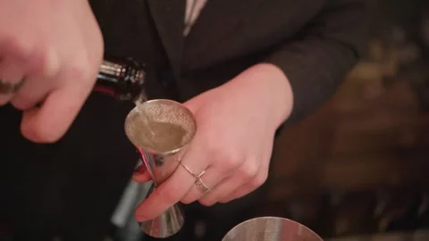 Bartender Pouring Liquor into Jigger over Cocktail Shaker Stock Footage 330815140