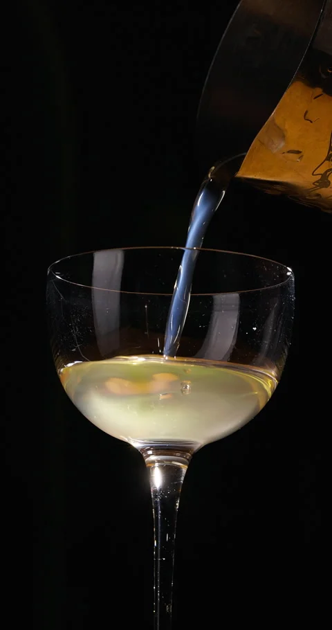 Bartender pouring refreshing yellow cocktail from shaker on black background Stock Footage 311694110