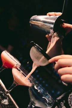 Bartender pouring using strainer White healthy Cocktail drink on a bar counte Stock Photos