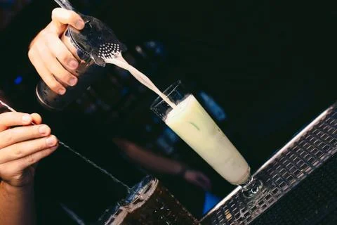Bartender pouring using strainer White healthy Cocktail drink on a bar counte Stock Photos