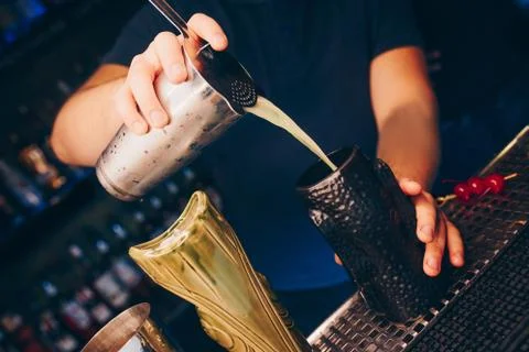 Bartender pouring using strainer White healthy Cocktail drink on a bar counte Stock Photos