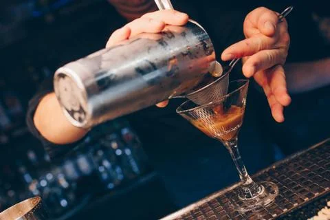 Bartender pouring using strainer White healthy Cocktail drink on a bar counte Stock Photos