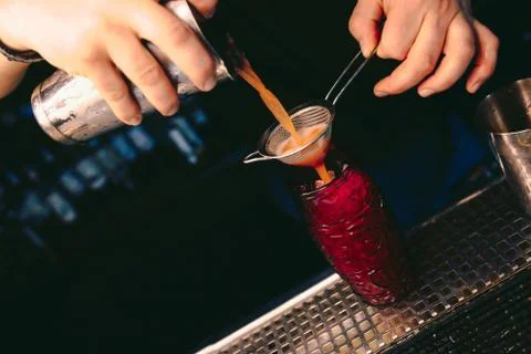 Bartender pouring using strainer White healthy Cocktail drink on a bar counte Stock Photos