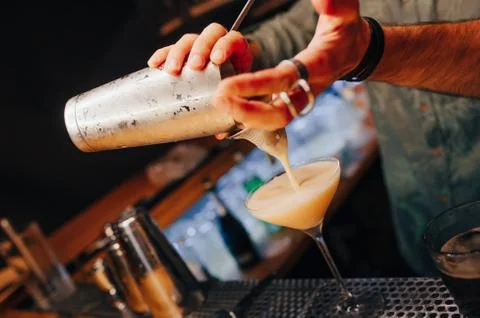 Bartender pouring using strainer White healthy Cocktail drink on a bar counte Stock Photos