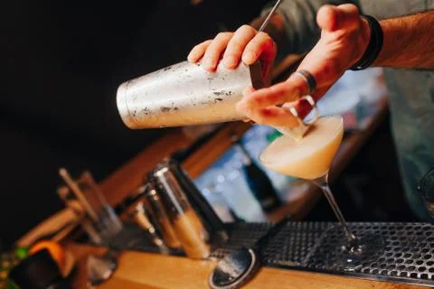 Bartender pouring using strainer White healthy Cocktail drink on a bar counte Foto stock