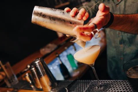 Bartender pouring using strainer White healthy Cocktail drink on a bar counte Stock Photos