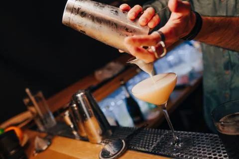 Bartender pouring using strainer White healthy Cocktail drink on a bar counte Foto stock