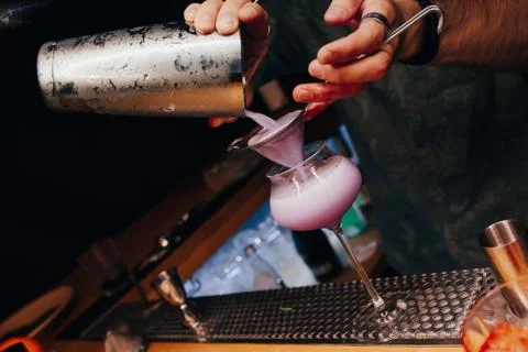 Bartender pouring using strainer White healthy Cocktail drink on a bar counte Stock Photos