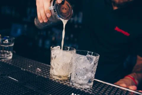 Bartender pouring using strainer White healthy Cocktail drink on a bar counte Stock Photos