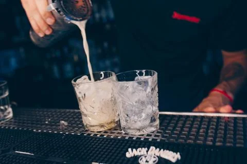 Bartender pouring using strainer White healthy Cocktail drink on a bar counte Stock Photos