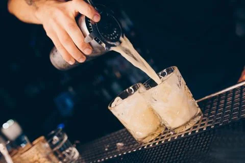 Bartender pouring using strainer White healthy Cocktail drink on a bar counte Stock Photos