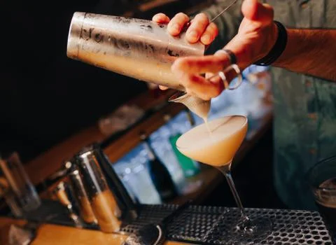 Bartender pouring using strainer White healthy Cocktail drink on a bar counte Stock Photos