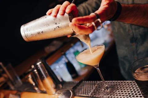 Bartender pouring using strainer White healthy Cocktail drink on a bar counte Stock Photos