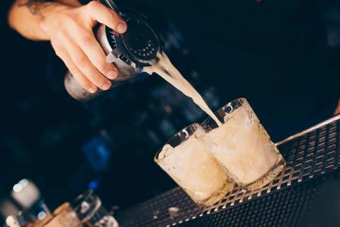 Bartender pouring using strainer White healthy Cocktail drink on a bar counte Stock Photos