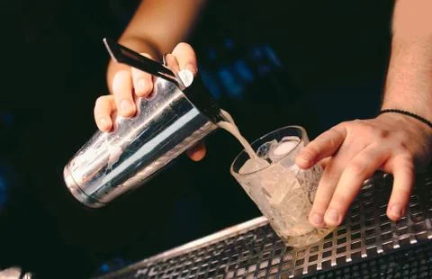 Bartender pouring using strainer White healthy Cocktail drink on a bar counte Stock Photos