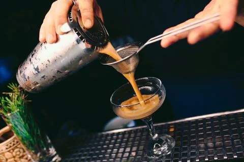 Bartender pouring using strainer White healthy Cocktail drink on a bar counte Stock Photos