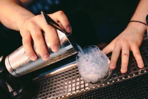 Bartender pouring using strainer White healthy Cocktail drink on a bar counte Stock Photos