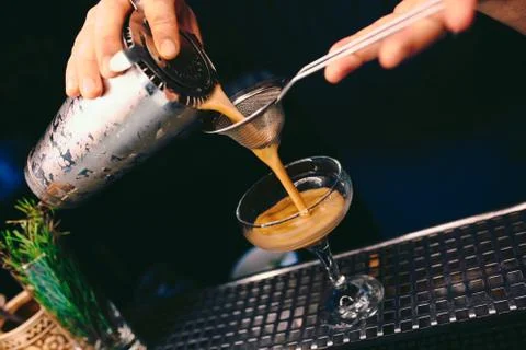 Bartender pouring using strainer White healthy Cocktail drink on a bar counte Stock Photos