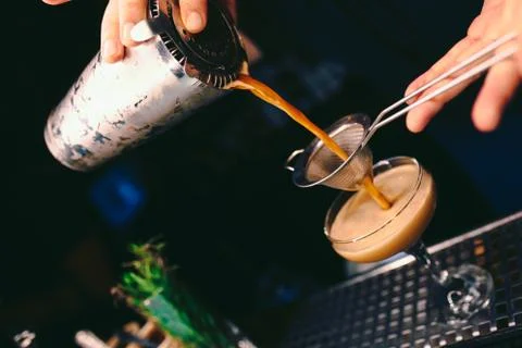 Bartender pouring using strainer White healthy Cocktail drink on a bar counte Stock Photos