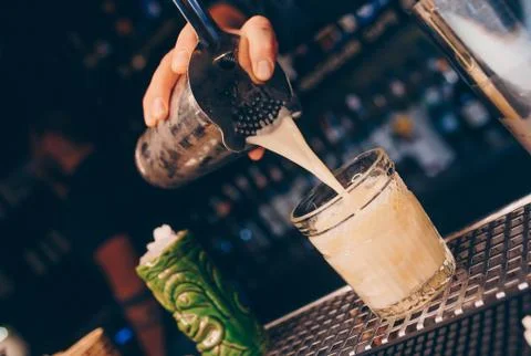 Bartender pouring using strainer White healthy Cocktail drink on a bar counte Stock Photos