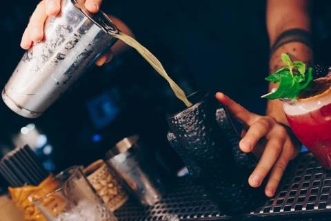 Bartender pouring using strainer White healthy Cocktail drink on a bar counte Stock Photos
