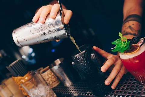 Bartender pouring using strainer White healthy Cocktail drink on a bar counte Stock Photos