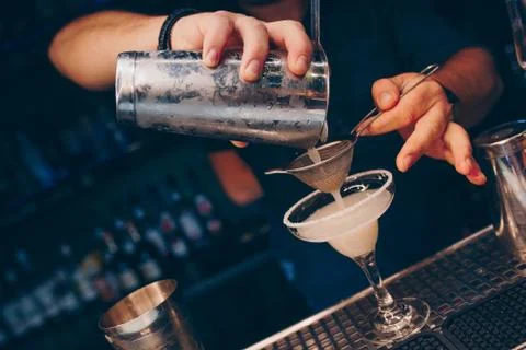 Bartender pouring using strainer White healthy Cocktail drink on a bar counte Stock Photos