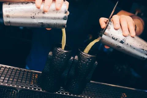 Bartender pouring using strainer White healthy Cocktail drink on a bar counte Stock Photos