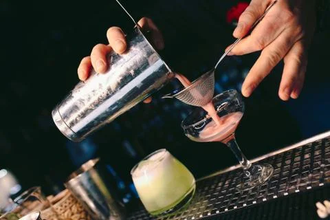 Bartender pouring using strainer White healthy Cocktail drink on a bar counte Stock Photos