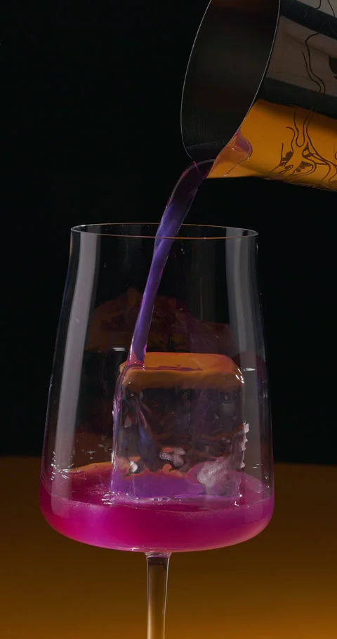 Bartender pouring violet refreshing cocktail on ice cube. Summer drink with Stock Footage 308417588