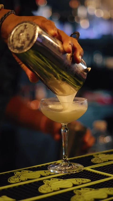 Bartender pouring yellow basil cocktail vertical 4K video Stock Footage 317408598