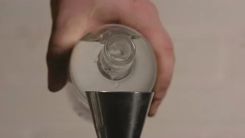The bartender pours alcohol from a bottle into a jigger measuring glass Stock Footage 185020875