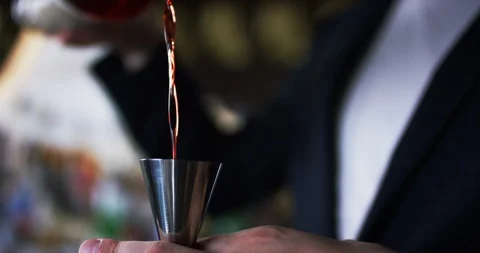 Bartender pours alcohol to the jigger, preparing cocktail in the bar slow motion Stock Footage 106468674